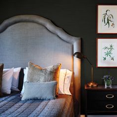 a bedroom with two framed pictures on the wall and a bed in front of it