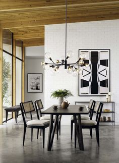 a dining room table with chairs and a potted plant