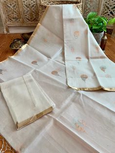 An exquisite pure 100% silk organza/kora benarasi saree in off white with copper & silver alfi buta (floral motif) woven throughout the six yards, along with a sleek golden border on either side. This saree is very stylish and classy, especially because of its simplicity and grace. The alfi (technique in Benaras weaving using two colored yarns) buta looks so stunning with the silver and copper zari as it keeps alternating with each motif. The pallu has a solid copper zari weaving. The fabric White Cotton Silk Festive Sets, Festive White Cotton Silk Set, White Cotton Silk Sets With Zari Work, White Cotton Silk Sets For Diwali, Diwali White Cotton Silk Sets, White Chanderi Traditional Drape Sets, White Raw Silk Sets With Cutdana Detailing, White Cotton Silk Dupatta For Wedding, White Silk Sets With Sheer Dupatta