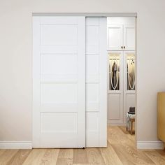 an empty room with white doors and wooden floors