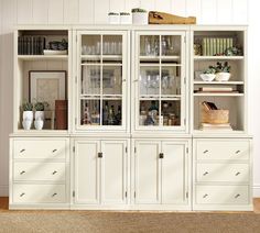 a white china cabinet with glass doors and drawers