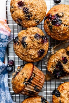 blueberry muffins cooling on a wire rack with a bite taken out of one