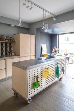 a kitchen with an island and lots of cupboards next to a large glass window