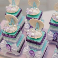 there are many small cakes with seashells and pearls in them on the table