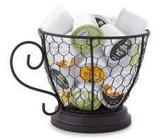 a black wire basket filled with white and green teas on top of a table