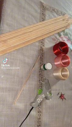 several different types of thread and sewing needles on a tablecloth with other items nearby