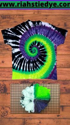 a tie - dyed t - shirt is sitting on top of a wooden floor next to other items