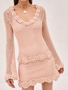 a woman is wearing a pink crochet dress