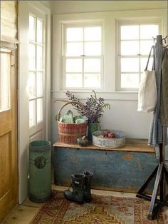 a room that has some plants on the window sill and a rug in front of it