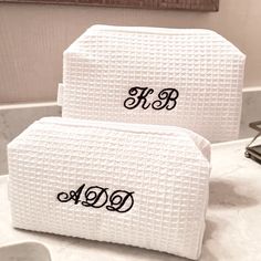 two personalized white towels sitting on top of a bathroom counter