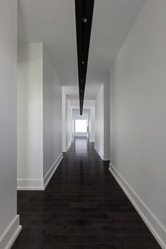 a long hallway with pink lines on the floor and a person standing in the distance