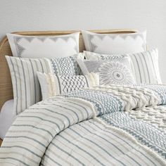 a bed with white and blue striped comforters