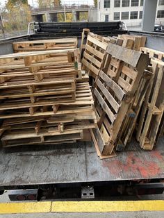 large pile of wooden pallets sitting on the back of a truck