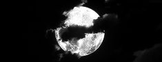 black and white photograph of the moon with clouds