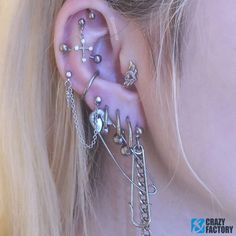 a close up of a person with ear piercings and chains on their ears,