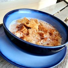 a blue bowl filled with food on top of a wooden table