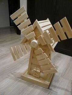 a sculpture made out of wooden blocks sitting on top of a hard wood floor