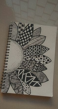 a spiral notebook with black and white designs on it