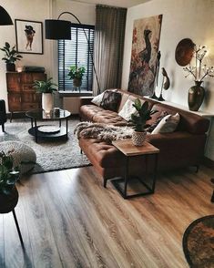 a living room filled with lots of furniture and decor on top of hard wood flooring