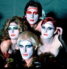 four people with painted faces posing for a photo