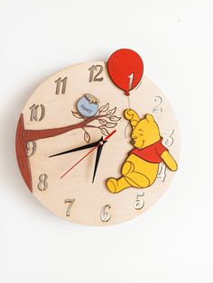 a wooden clock with winnie the pooh and balloon attached to it's face