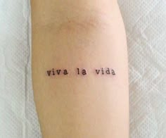 a woman's arm with the words vive la vida written on it in cursive font