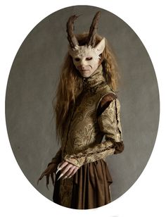 a woman with long hair and horns wearing a costume