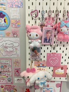 hello kitty keychains hanging on a wall with pictures and other items attached to it