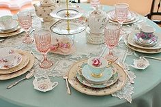 the table is set with pink and white china