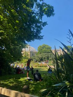 people sitting on the grass in a park