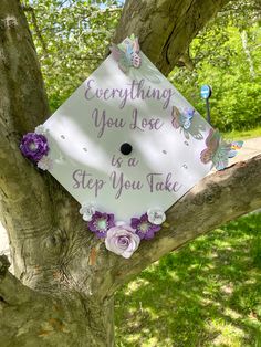 a white graduation cap with purple flowers on it that says, everything you do in a step you take