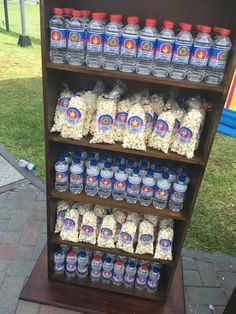 a shelf filled with lots of water bottles and bags of popcorn on top of it