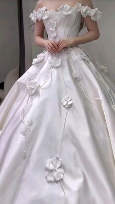 a woman in a white wedding dress with flowers on it