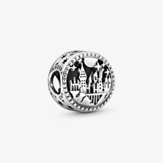 a silver bead with an image of a castle and trees in the middle, on a white background