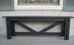 a wooden bench sitting in front of a window