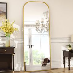 a large mirror sitting on top of a wooden floor next to a table and chair