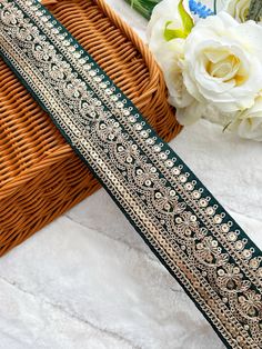 a close up of a ribbon on a table next to flowers and a wicker basket