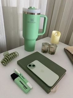 the contents of a green coffee cup sitting on top of a table next to a cell phone