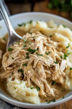 a white bowl filled with chicken and mashed potatoes