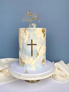 a cake with a cross on top is sitting on a white platter and blue background