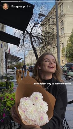 a woman sitting on a bench holding a bouquet of flowers with the caption, the best way to make me smile