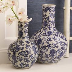 two blue and white vases with flowers in them