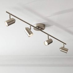 three spotlights are attached to the ceiling in a room with white walls and flooring