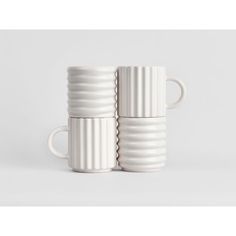 three white mugs stacked on top of each other in front of a white background