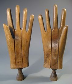 two wooden hand sculptures sitting on top of each other