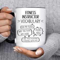 a woman holding a coffee mug with the words, fitness instructor vocably on it