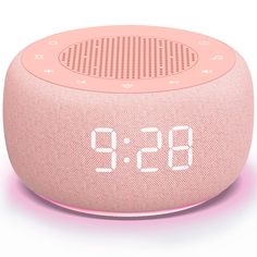 the alarm clock is pink and has white numbers on its front side, as well as an hour