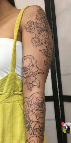 a woman with a flower tattoo on her arm holding a yellow tote bag in front of her