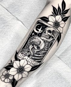 a black and white image of a jar with flowers on the arm, holding a skull