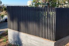 a fence made out of concrete blocks on the side of a road